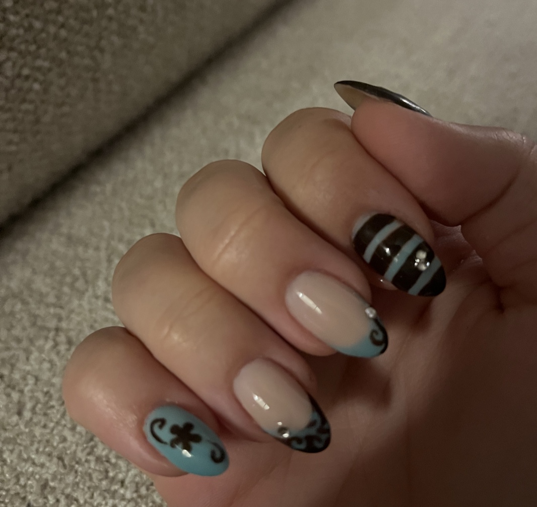 Nude amandelnagels met zwarte strepen, steentjes en blauwgrijze nail art